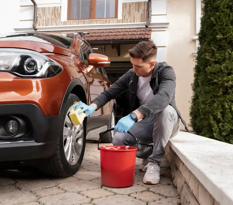 Lavage auto à domicile Bazoches-sur-Guyonne : professionnel intervenant sur un véhicule